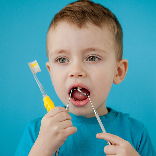 Cute little boy playing with dental tools